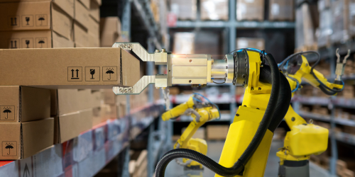 Industrial robot removing box from wall in warehouse.